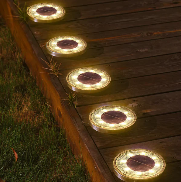 Solar-powered deck lights on a wooden surface