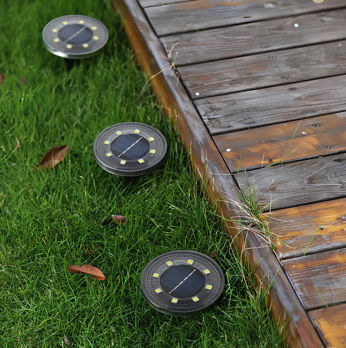 Solar-powered outdoor lights on grass next to a wooden deck