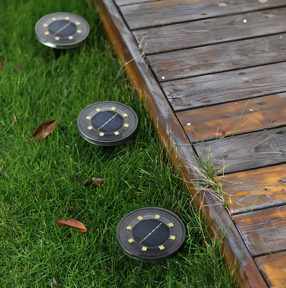 Solar-powered outdoor lights on grass next to a wooden deck